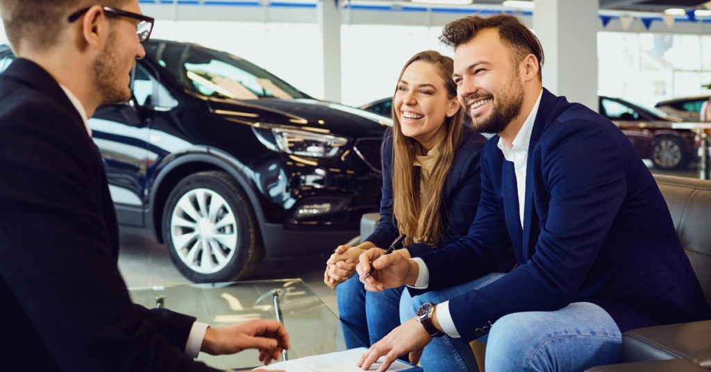 couple discussing auto financing options with a salesperson at a car dealership